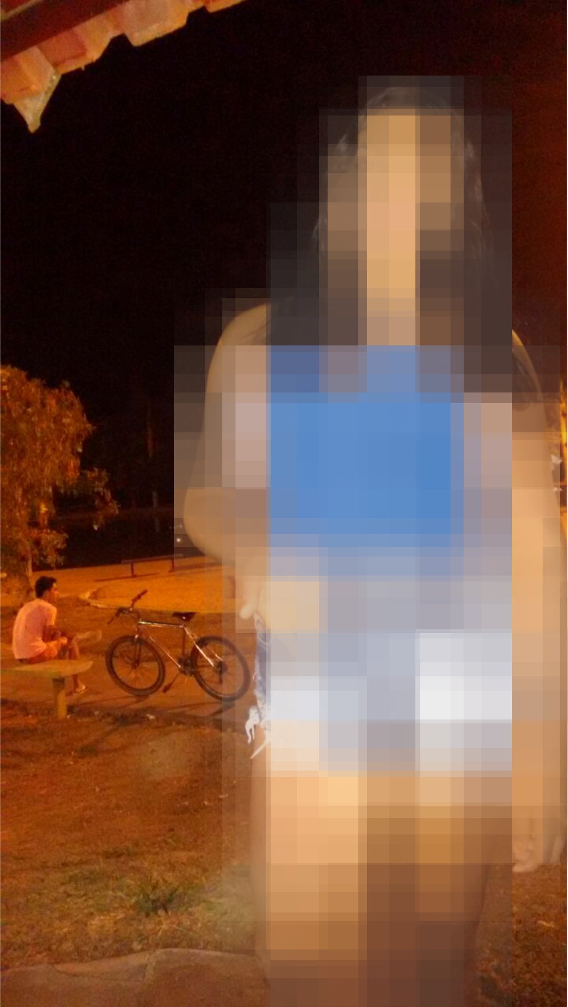 NESSA FOTO A VÍTIMA APARECE AO FUNDO, SENTADA EM UM BANCO, PARECENDO ESPERAR POR ALGUÉM